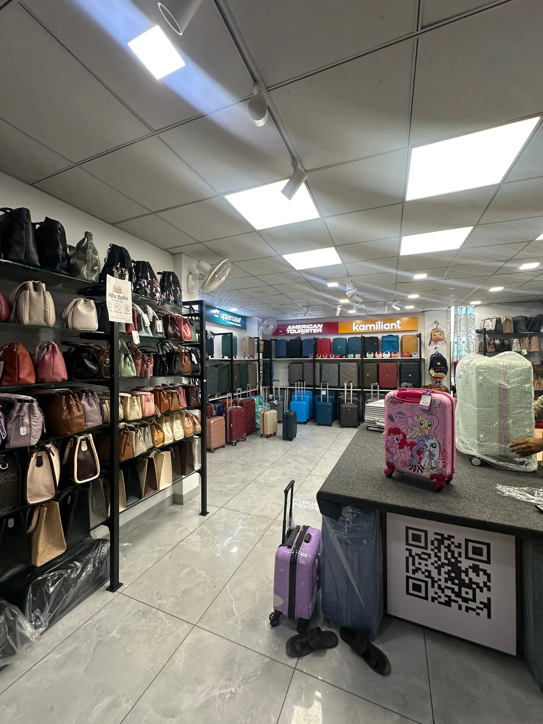 Inside Rama Bags, handbag shelves lead along the aisle to the luggage displays.